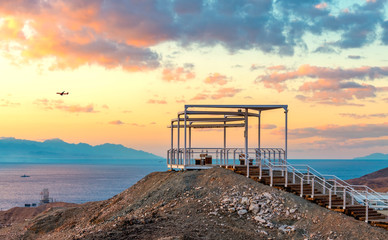 Fototapeta na wymiar Sunrise at a top of the mount and illuminated stair-steps and pergola, photo taken in nature public park, vicinity of Eilat - famous tourist resort and recreational city in Israel