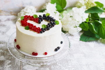 Round white cake with berries in the form of hearts, Valentine's Day, on white background. Picture for a menu or a confectionery catalog. Top view