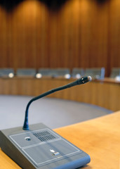 Conference room with wooden walls and microphones at each seat