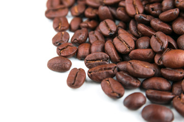 Dark coffee beans placed on a white scene.