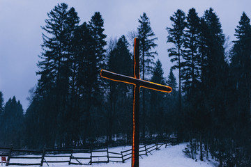 Photo of light cross during evening and snow in mountains