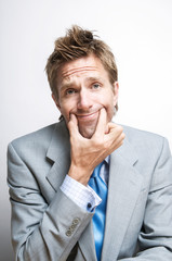 Tired businessman forcing a smile by holding up the corners of his mouth with his fingers