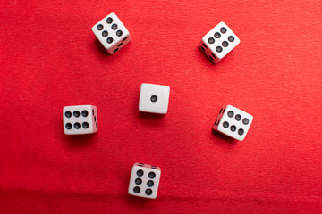 Hand throwing dice, hoping for the best odds. Six dice on red background