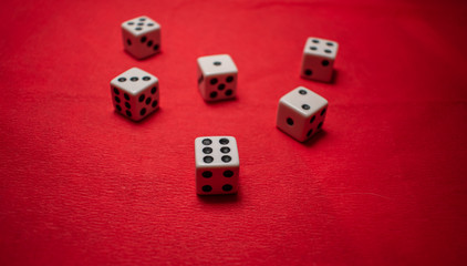Hand throwing dice, hoping for the best odds. Six dice on red background