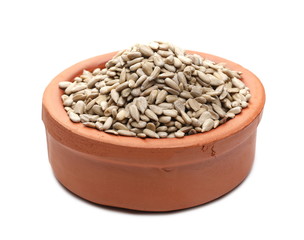 Peeled sunflower seeds in clay bowl isolated on white background