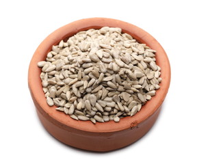 Peeled sunflower seeds in clay bowl isolated on white background
