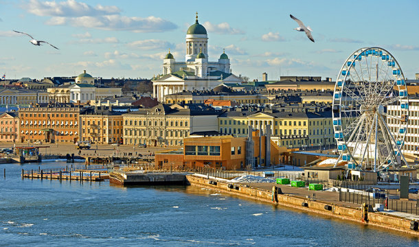 HELSINKI, FINLAND - MARCH 26, 2018: View of from sea. Market Square, Lutheran Helsinki Cathedral (Tuomiokirkko), Finnair Sky Wheel (Observation Wheel) and Allas Sea Pool and seagulls in South Harbour
