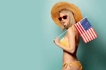 Beautiful blonde woman in bikini with flag of USA