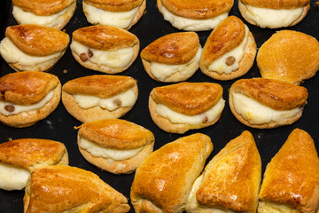 Fresh small pies with filling on a baking sheet