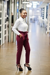 Charming african american woman in formal wear posing at restaurant.