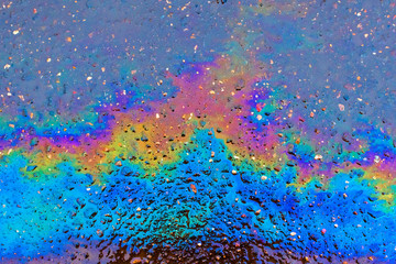 Bright multi-colored oil stain on the asphalt. Abstract background for lettering or design.