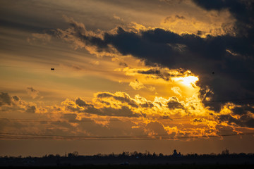 Obraz premium Sky at sunset with dark clouds and sun behind