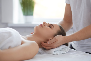 Obraz na płótnie Canvas Young beautiful woman enjoying anti-aging facial massage.Male therapist making head massage to female client.Professional masseur.Relaxation,beauty,spa,body and face treatment concept.