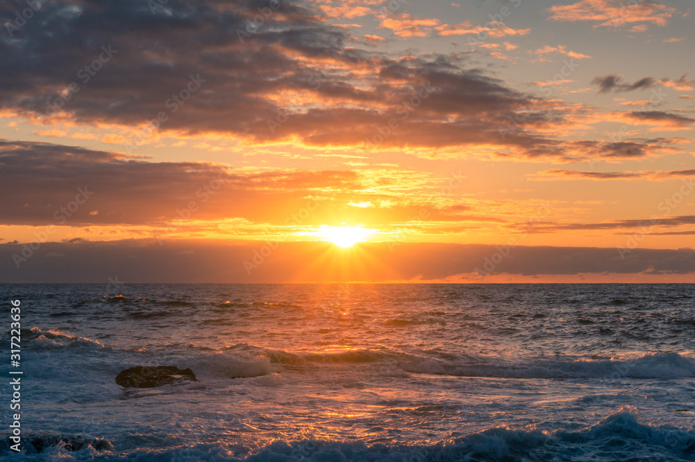 Wall mural epic sunrise landscape with sea, ocean and bright sun with rays