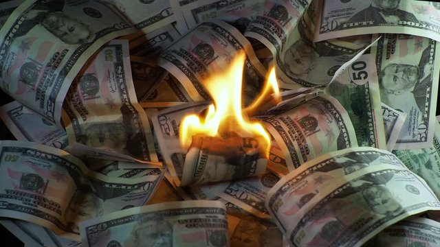 A lot of dollars in the fire, the global financial crisis and inflation, the concept. Lots of burning dollar bills, burning and Smoking, natural shooting