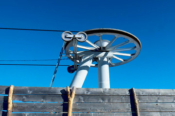 Rotating wheels of skiing drag lift on top of mountains slope, small ski resort