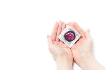 color condom in female hand isolated on a white background