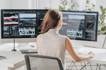 back view of filmmaker working near computer monitors