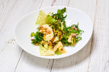 Mix salad of fresh vegetables, tuna, eggs on a white wooden background. Healthy and wholesome organic food, diet, proper nutrition concept.