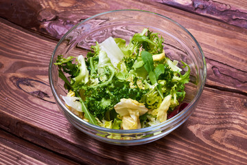 Vegetarian salad mix of fresh vegetables on a wooden background. Healthy and wholesome organic food, diet, proper nutrition concept.