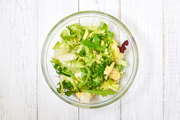 Vegetarian salad mix of fresh vegetables on a light wooden background. Healthy and wholesome organic food, diet, proper nutrition concept.