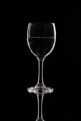 wine glass on a black background with contour lighting. Studio shot.
