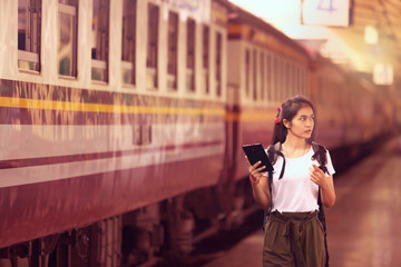 asian girl with backpack, travel by train, destination nature trip in summer