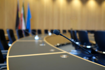 Conference room with wooden walls and microphones at each seat