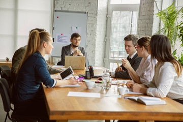 Competitor research. Group of young business professionals having a meeting. Diverse group of coworkers discuss new decisions, plans, results, strategy. Creativity, workplace, business, finance