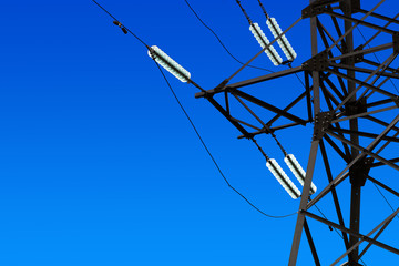High voltage power lines, blue sky background, electricity distribution station. Electric power...