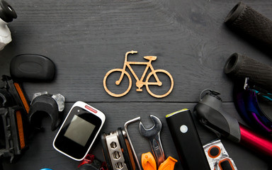 Fototapeta A lot of different bicycle accessories lying on wooden table around a little bicycle icon obraz
