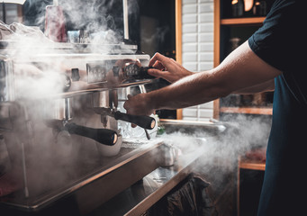 Barista preparing cappuccino on espresso machine for customer in coffee shop.