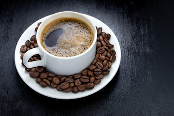 Coffee cup and saucer on a wooden table. Dark background.