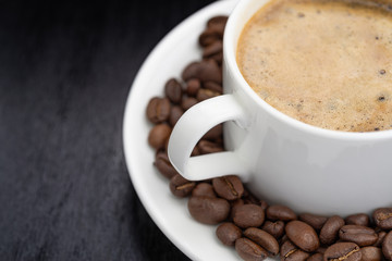 Coffee cup and saucer on a wooden table. Dark background.