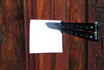 A note attached with a knife to the door. Note with space copying. Gang fights. Pressure on neighbors. Threat. Debt. Problems.