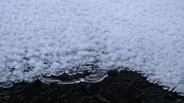 Video of openwork ice over the water of frozen river Pescherka in winter