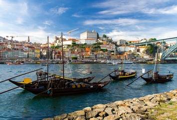 Obraz premium Portugal, city landscape Porto, wooden boats with wine port barrels close up on Douro, panoramic view of the old town Porto, The Eiffel Bridge view, Ponte Dom Luis, Porto in summer, colored houses