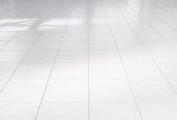 White tile floor background in perspective view. Clean, shiny, symmetry with grid line texture. For decoration in bathroom, kitchen and laundry room. And empty or copy space for product display also.