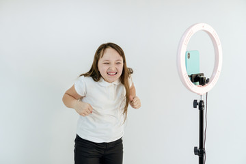 A teenage girl dances and shoots a video. Selfies. The phone is mounted on a tripod and the ring...