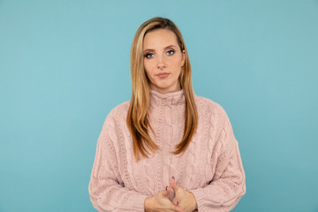 Portrait of handsome woman in the sweater posing on the blue background