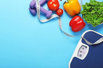 Different healthy food with measuring tape, scales and dumbbells on color background. Diet concept