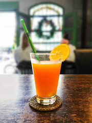 Exotic citrus juice glass with sliced orange on brown wooden table in cafe Phuket Thailand for get away concept