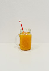 glass of orange juice with paper straw
