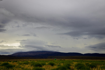 Naklejka na ściany i meble A thunder storm hanging over the mountains on the Robinson pass on its way to Oudtshoorn.