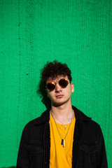 Portrait of a guy dressed modern in the street with sunglasses. Teenager Social Networking style photo