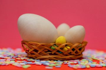 Easter composition. Eggs in a basket on a pink background, color decor.