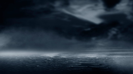 Dramatic black and white background. Cloudy night sky, moonlight, reflection on the pavement. Smoke and fog on a dark street at night.