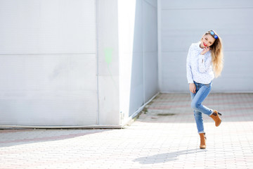 Girl dressed in tight jeans happy and cheerful dancing in the street.