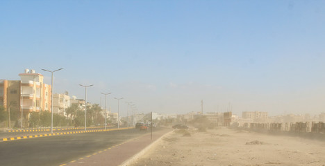 Fototapeta premium Sand storm in the desert. Dust storm on a street of the city of Hurghada, Egypt.