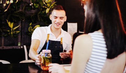 View over the shoulder. The girl choosing the menu and getting order at cafe.